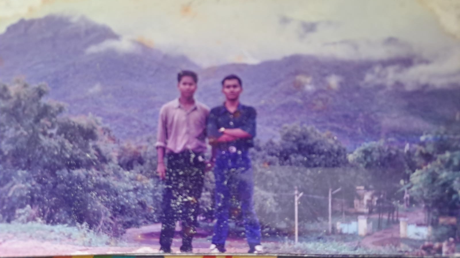 Two batchmates standing with the hills behind them on a trip